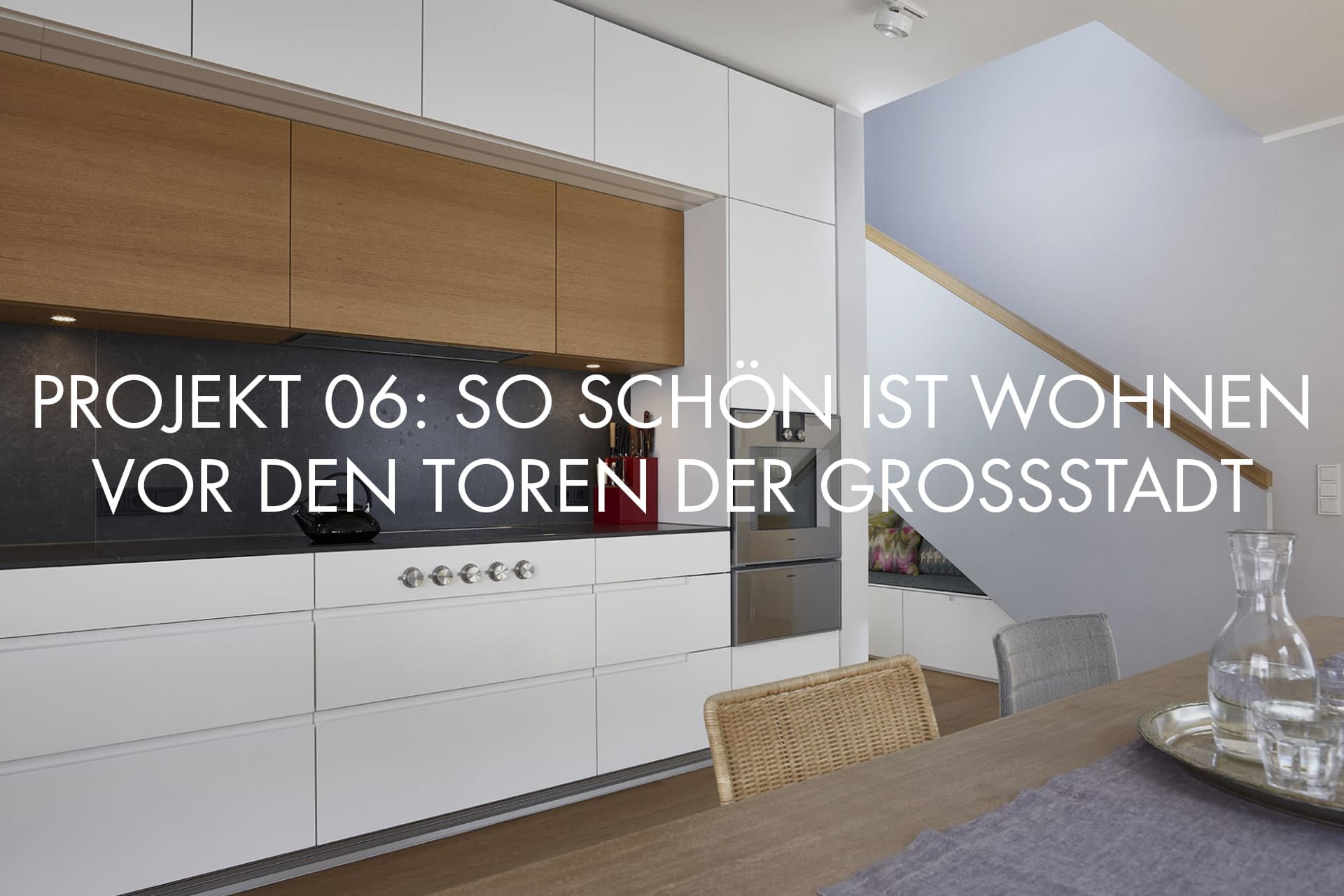 Inneneinrichtungsdesign von Voit, Küche mit weißen Fronten und schwarzer Arbeitsplatte, Eiche natur, BetonART, Mattlack weiß, Edelstahl als zusätzliche Materialien + Schriftzug im Bild "Projekt 06: So schön ist Wohnen vor den Toren der Grossstadt"