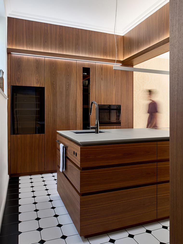 Küche mit Arbeitsplatte aus fugenlosem Beton mit Nussbaum Furnier in hellem offenen Raum